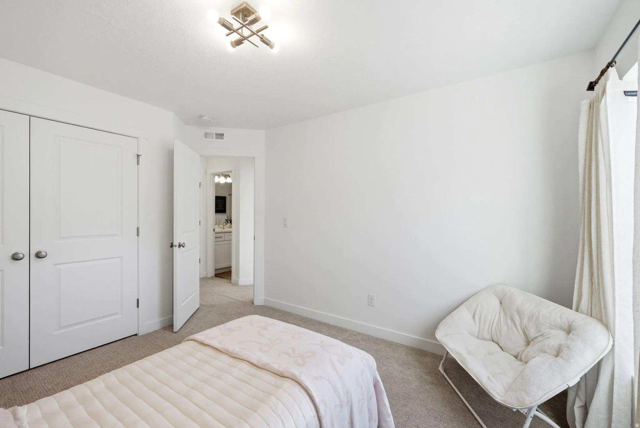 Bedroom with light colored carpet and a closet