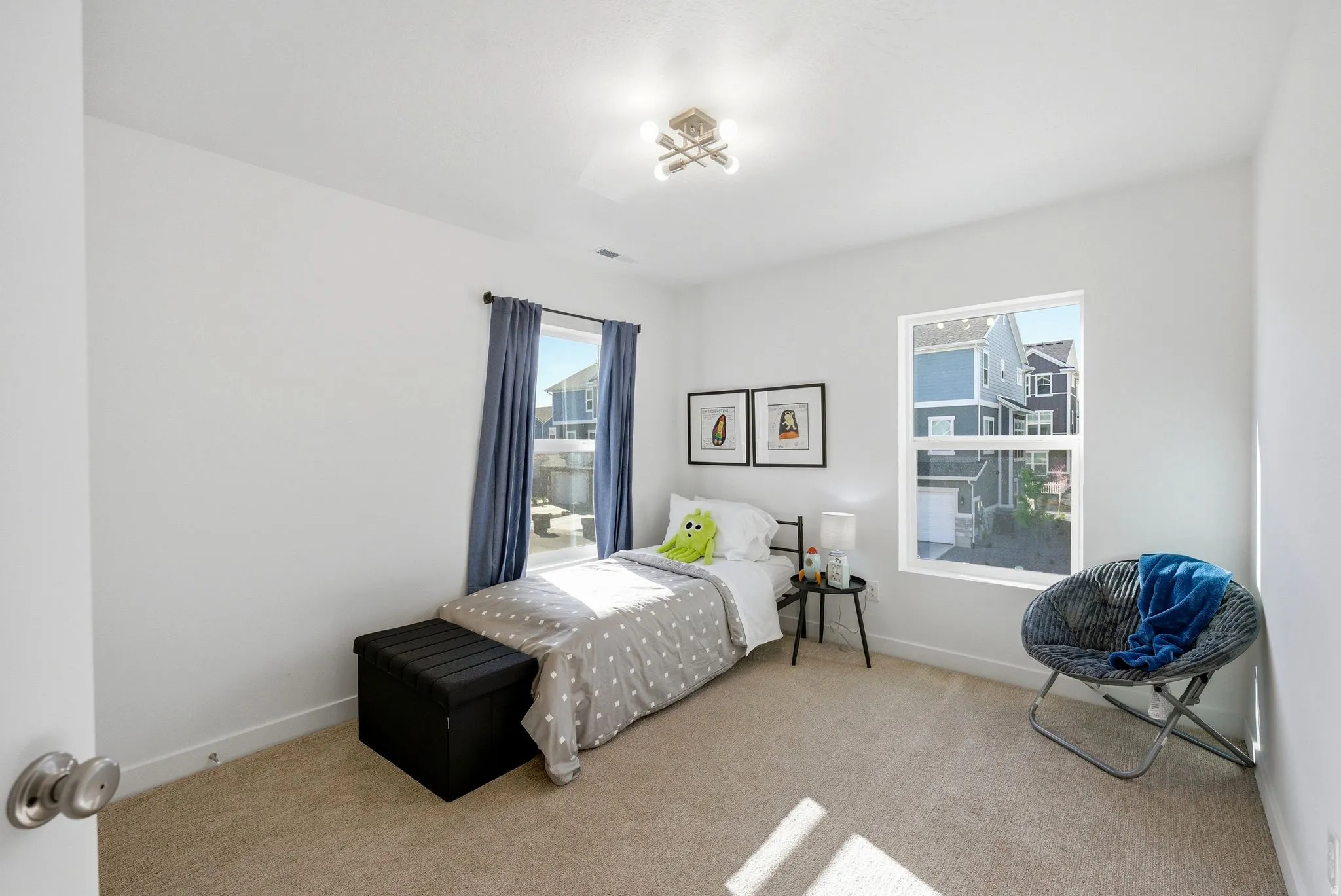 Bedroom featuring light colored carpet and multiple windows
