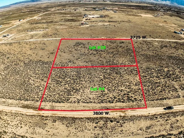 Aerial view of sparsely populated area with property parcel outlined and mountains