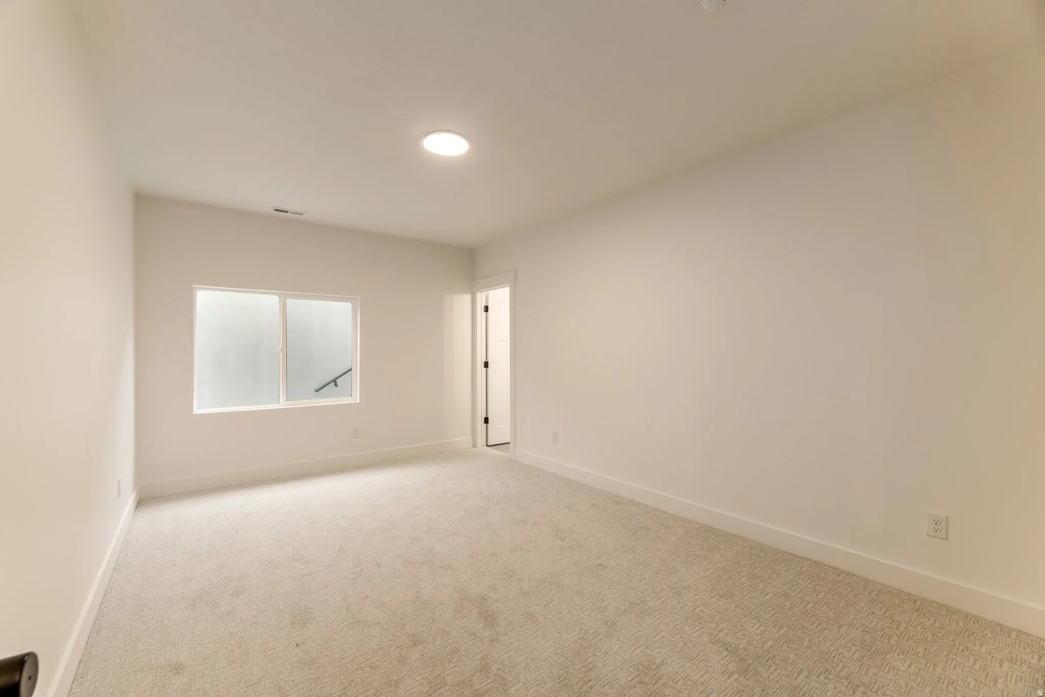 Carpeted empty room with baseboards