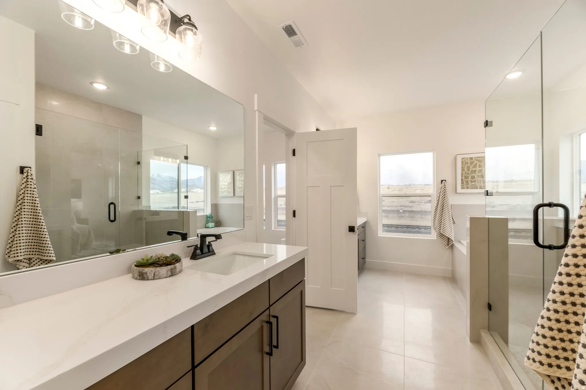 Bathroom with a stall shower, vanity, recessed lighting, light tile patterned flooring, and healthy amount of natural light