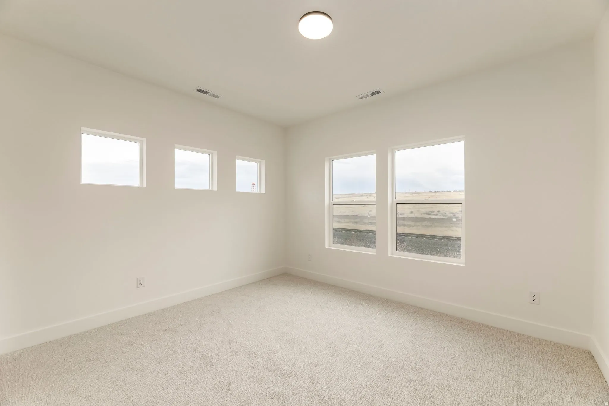 Unfurnished room with light colored carpet and baseboards