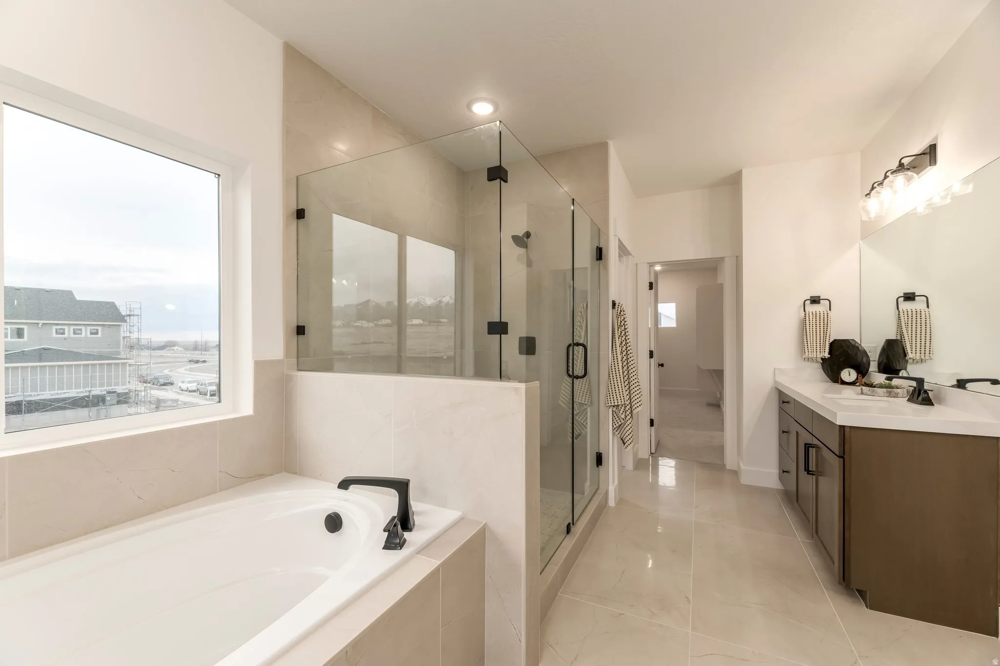 Full bathroom with a bath, vanity, and a stall shower