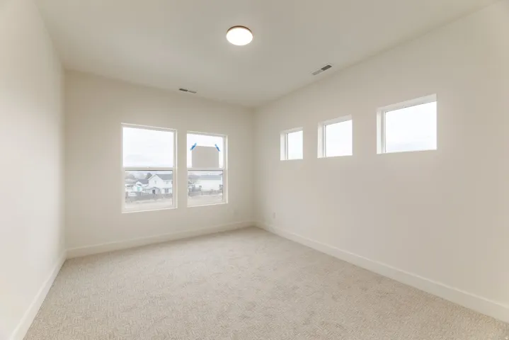 Spare room with light carpet and healthy amount of natural light
