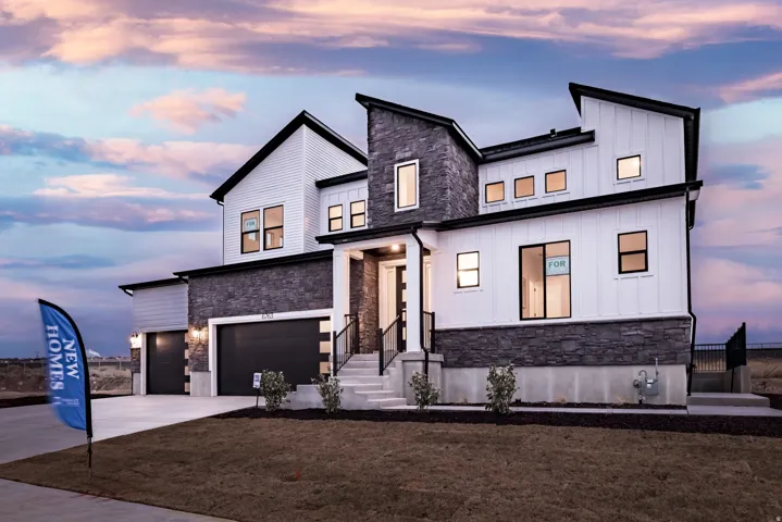 View of front of property featuring stone siding, board and batten siding, an attached garage, and driveway