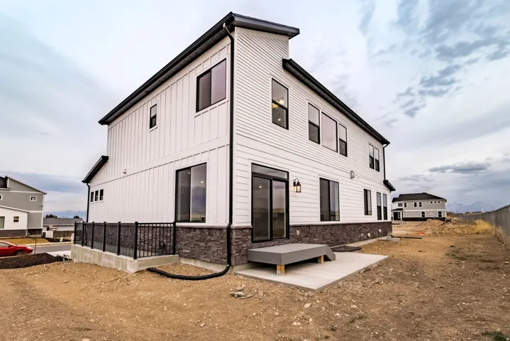 Rear view of property featuring stone siding and board and batten siding