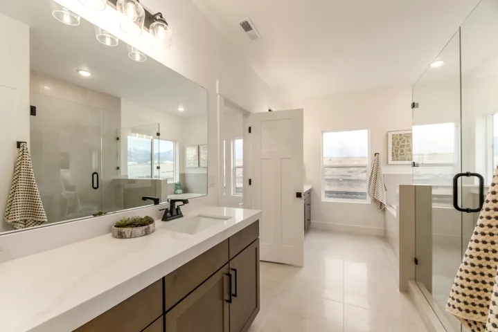 Bathroom with a stall shower, vanity, recessed lighting, light tile patterned flooring, and healthy amount of natural light