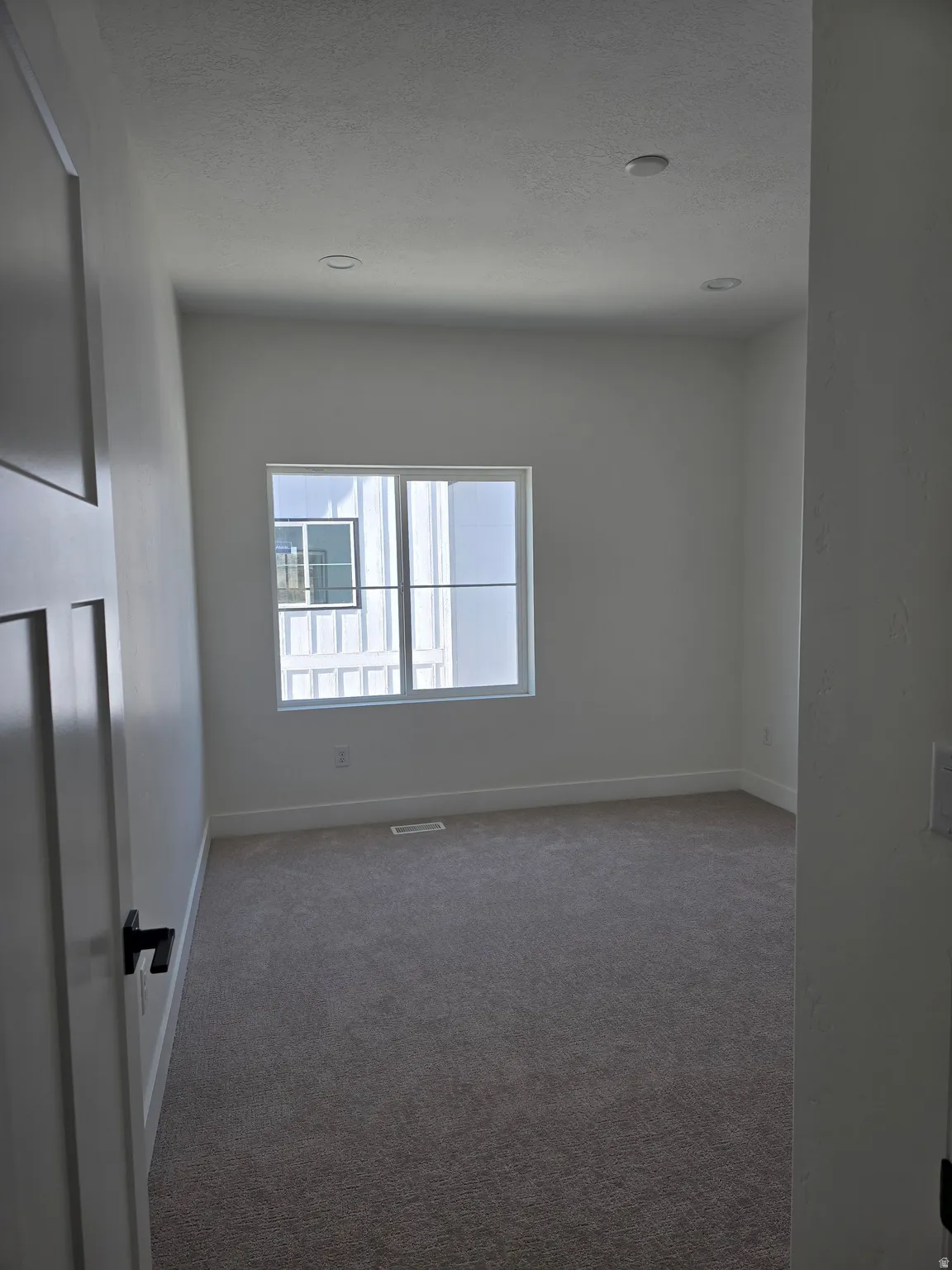 Carpeted bed room featuring baseboards and a textured ceiling