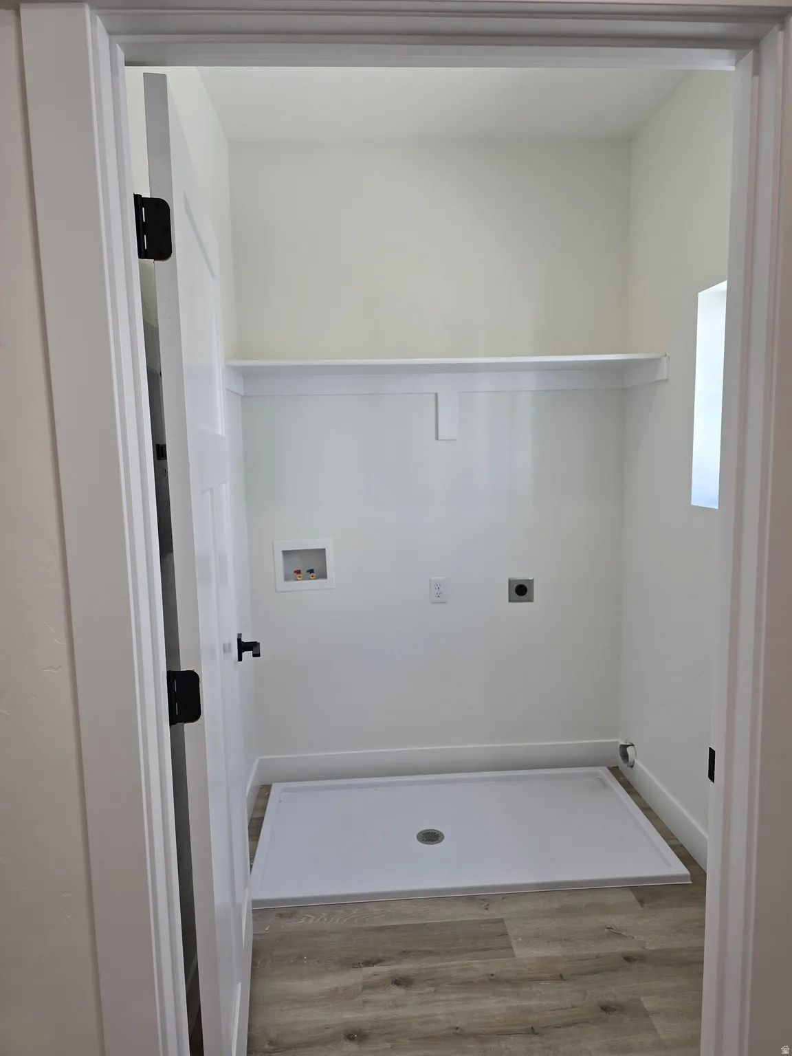 Laundry area featuring light wood finished floors, washer hookup, and hookup for an electric dryer