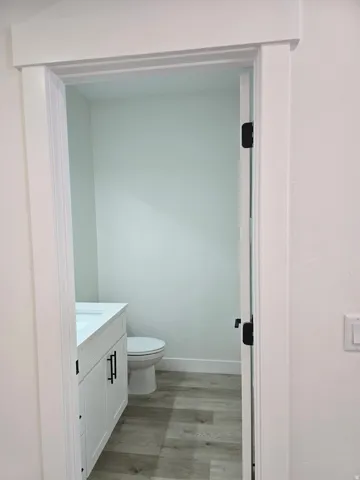 Half bathroom featuring vanity and light wood-style floors