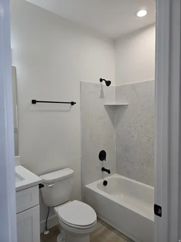 Full bathroom with vanity, washtub / shower combination, light wood-style floors, and recessed lighting
