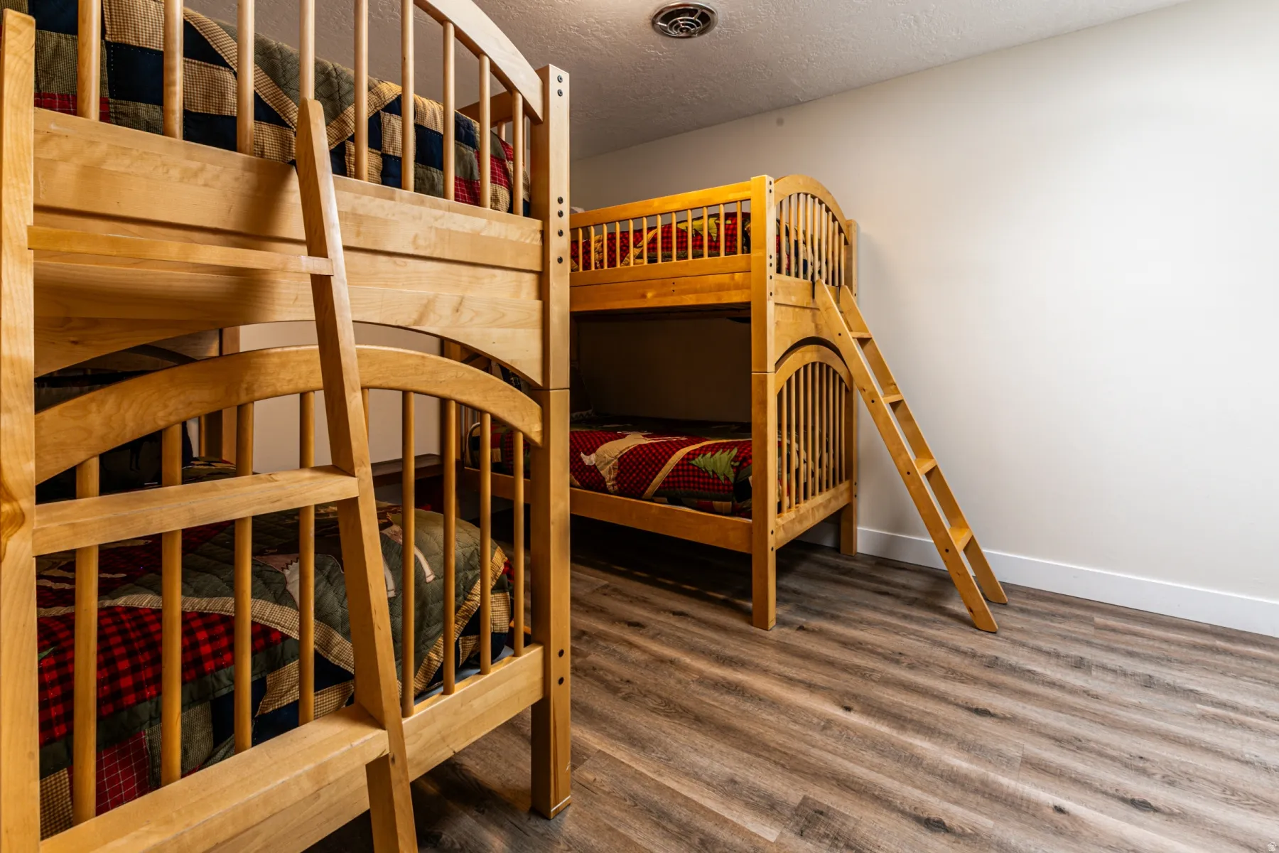 Bedroom featuring a textured ceiling and wood finished floors