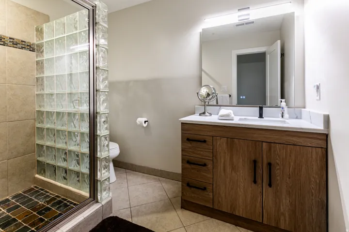 Full bathroom featuring a shower stall, vanity, and light tile patterned floors
