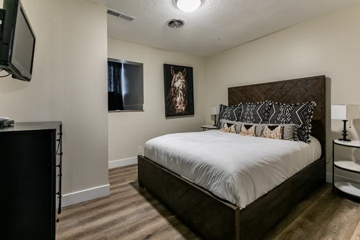 Bedroom with dark wood-style flooring and a textured ceiling