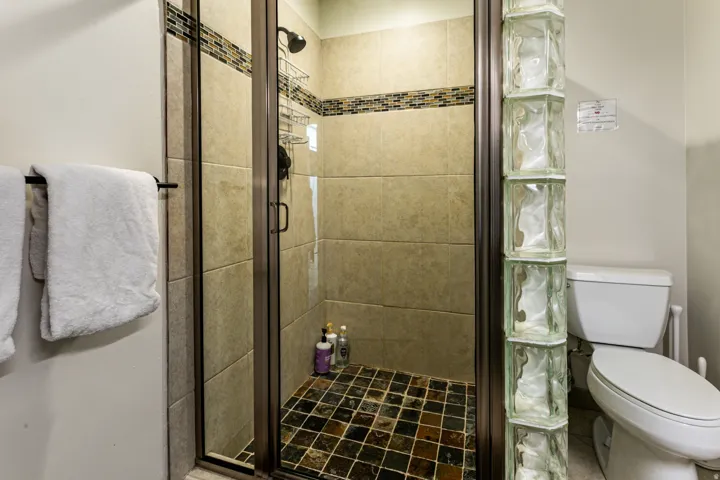 Bathroom featuring toilet and a stall shower
