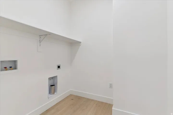 Laundry room with light wood-style floors, hookup for a washing machine, and electric dryer hookup