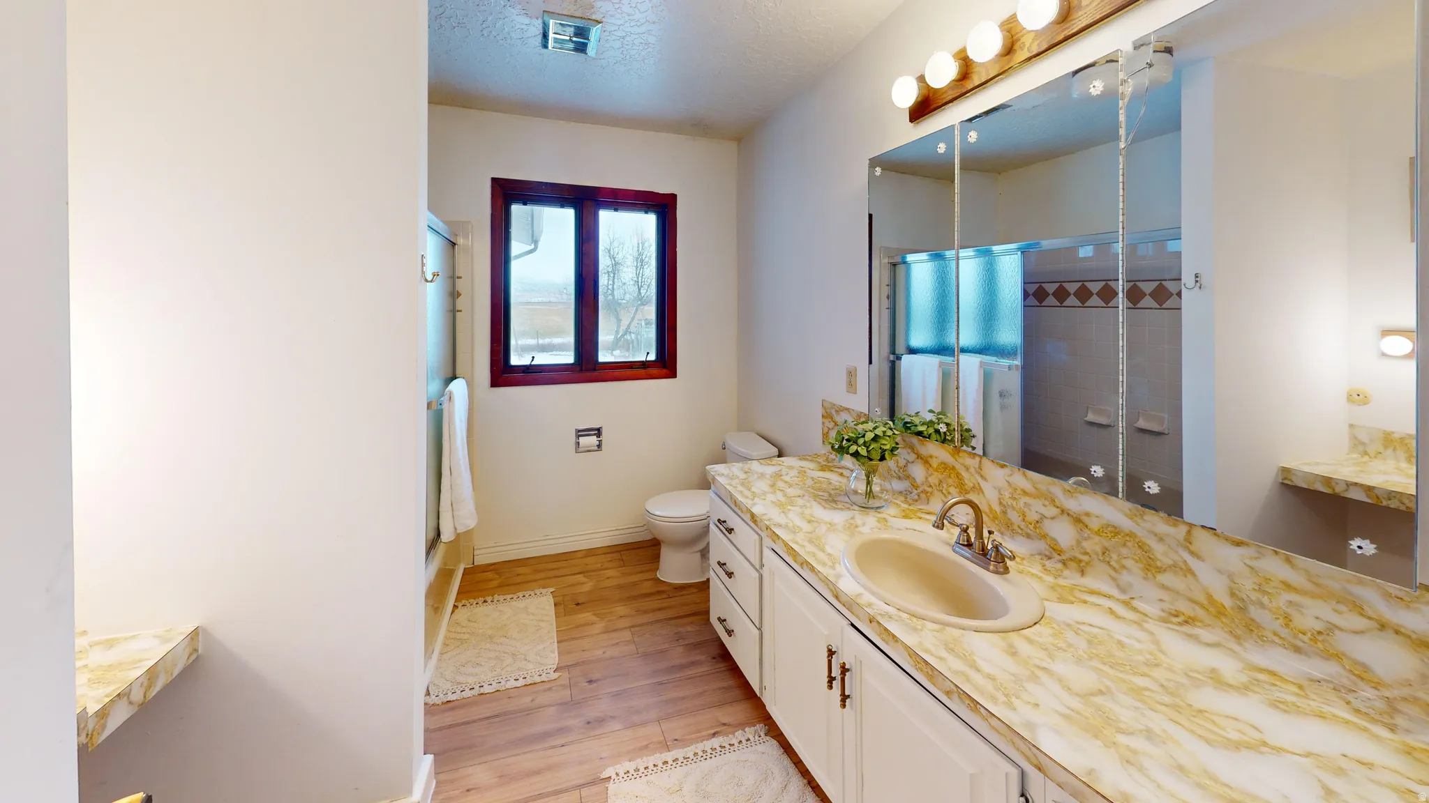 Bathroom featuring vanity, light wood finished floors, and a textured ceiling