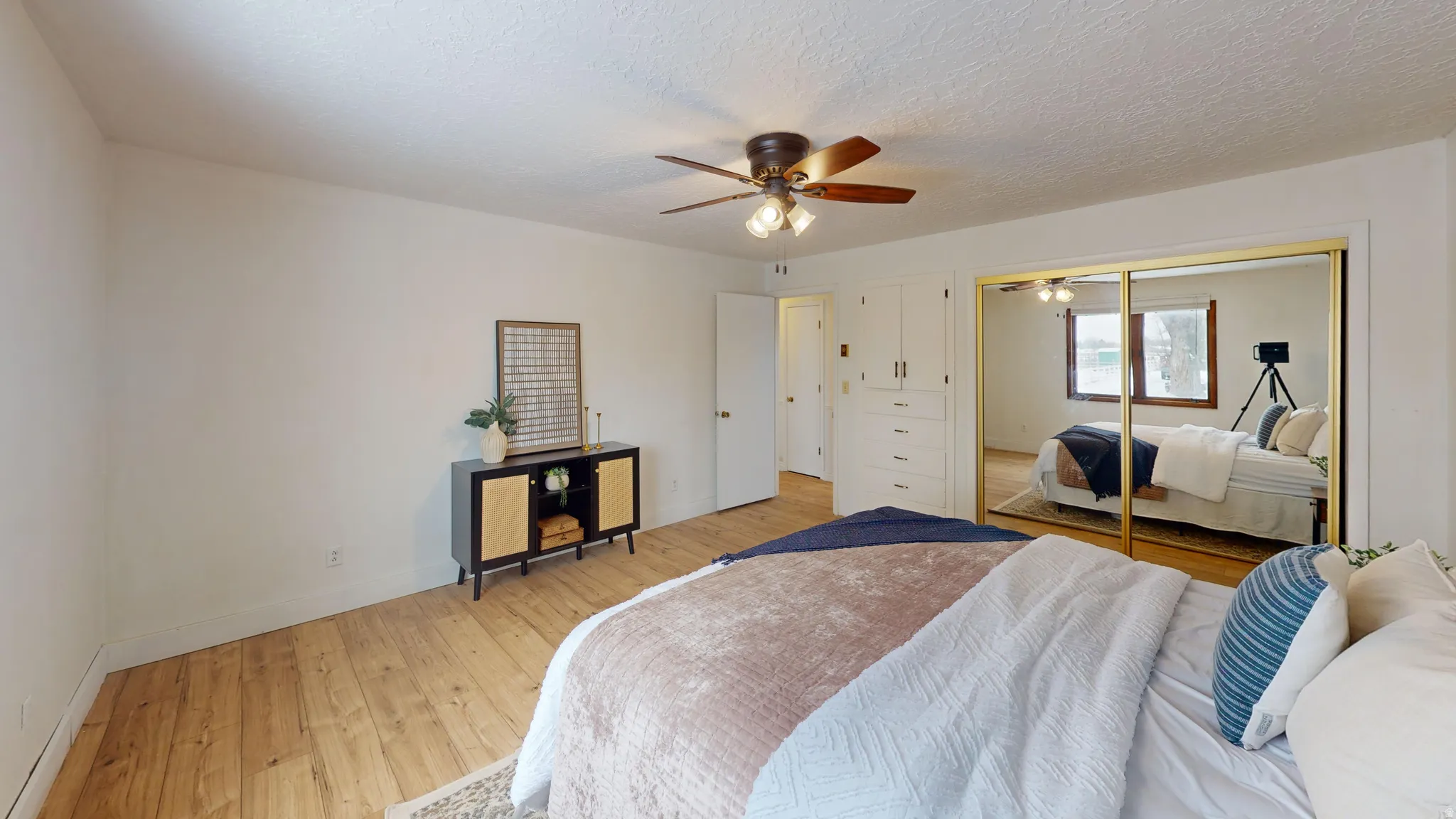 Bedroom with hardwood / wood-style flooring, a ceiling fan, a textured ceiling, and a closet