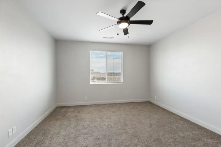 Plush carpeting, window with blinds, and ceiling fan with integrated lighting