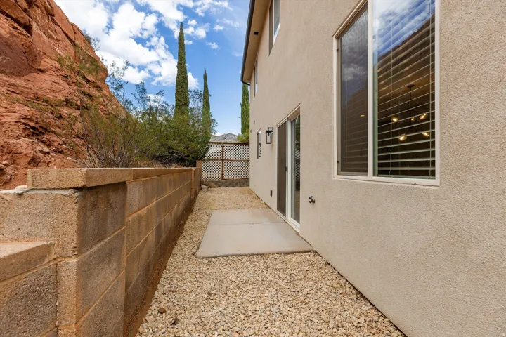 Stucco exterior with a sliding glass door and large window