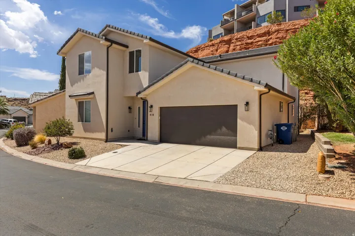 Stucco exterior featuring multi-pane windows and a concrete driveway