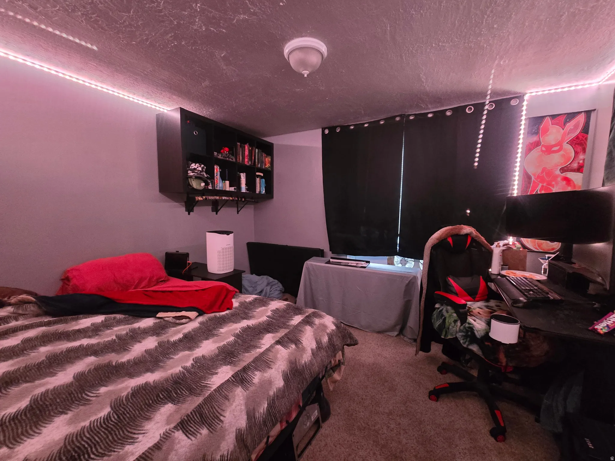 Carpeted bedroom with a textured ceiling and a desk