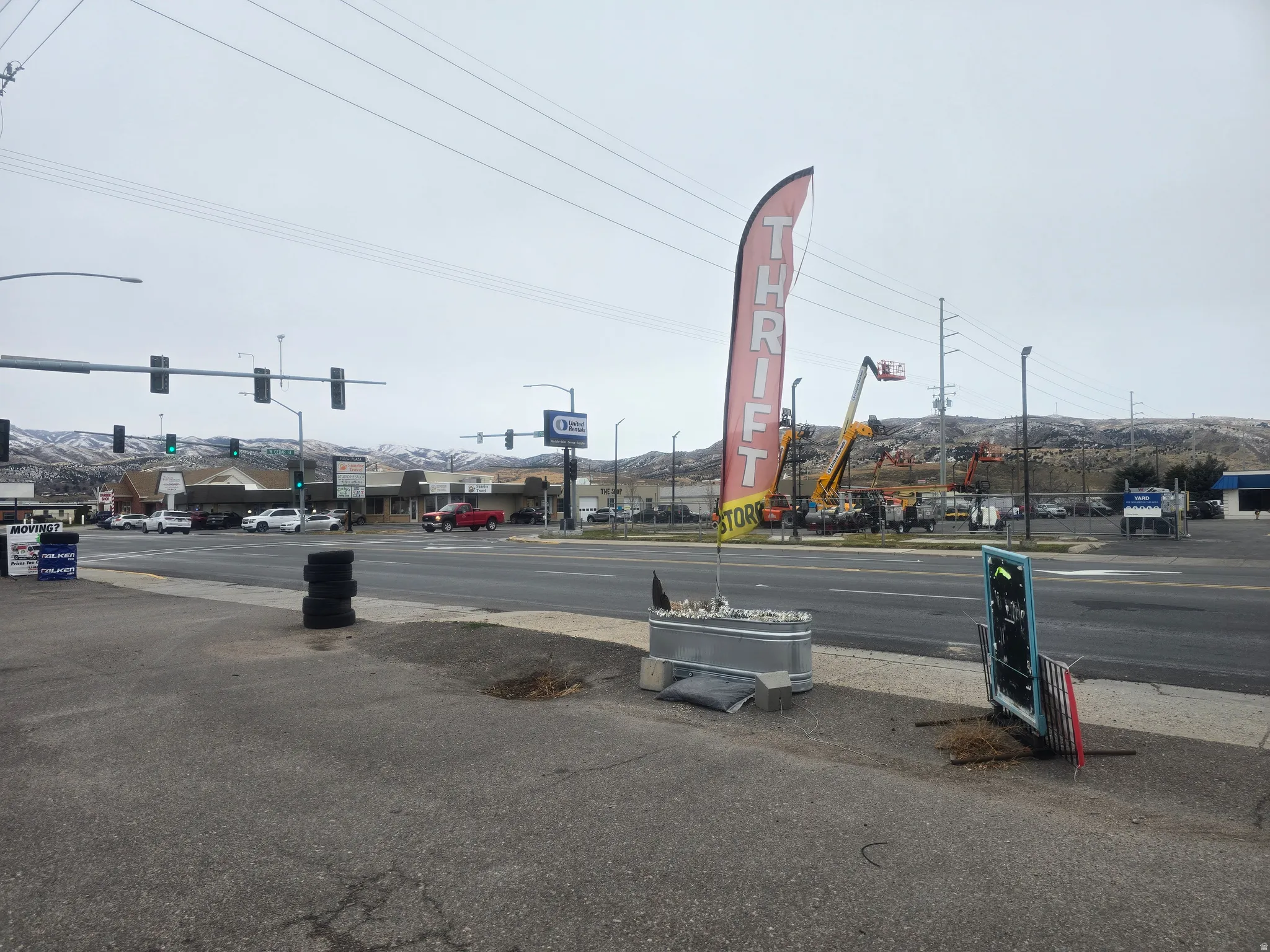 View of asphalt street featuring street lighting, a mountain view, traffic lights, and sidewalks