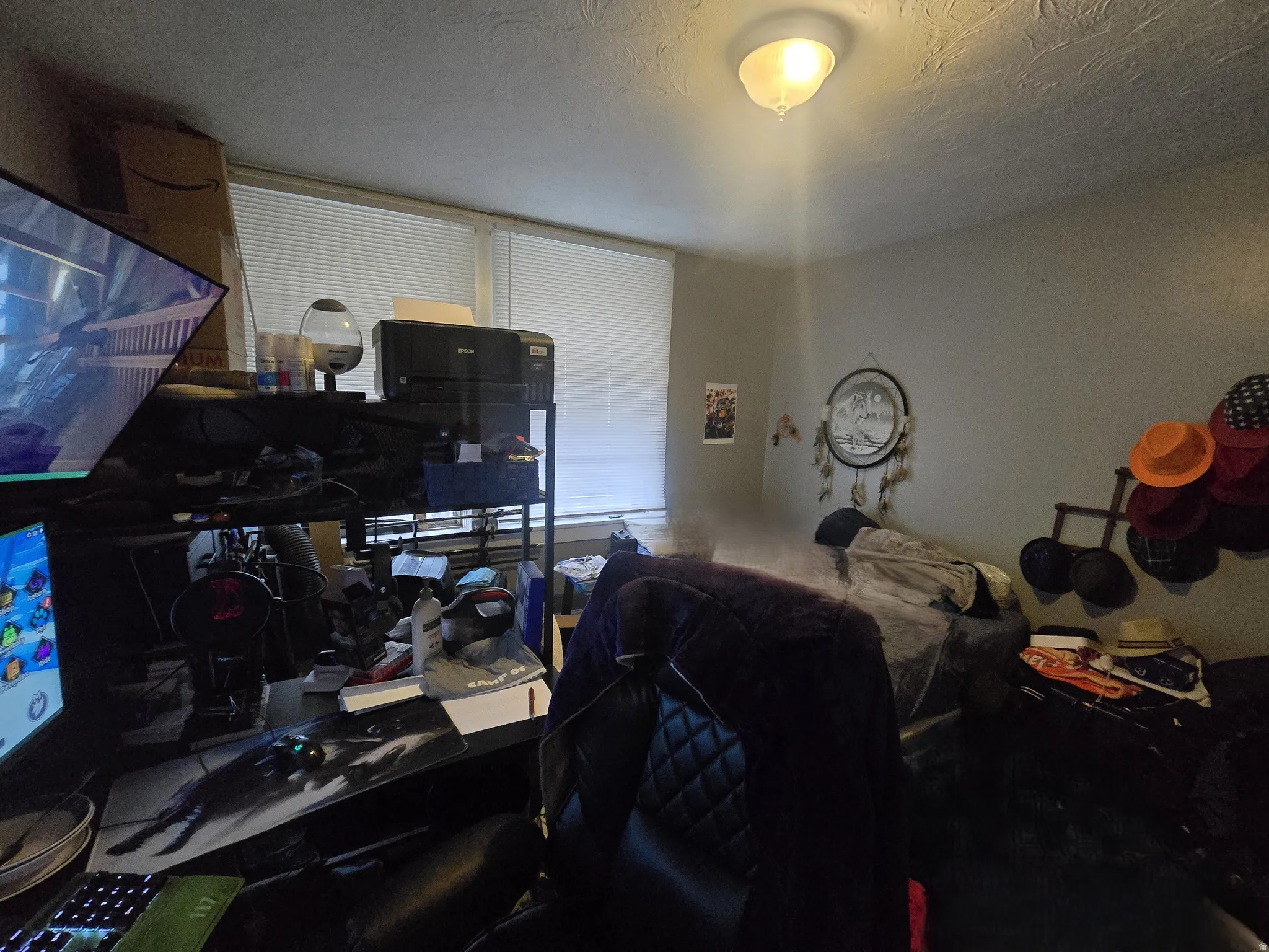 Bedroom with a textured ceiling and a desk
