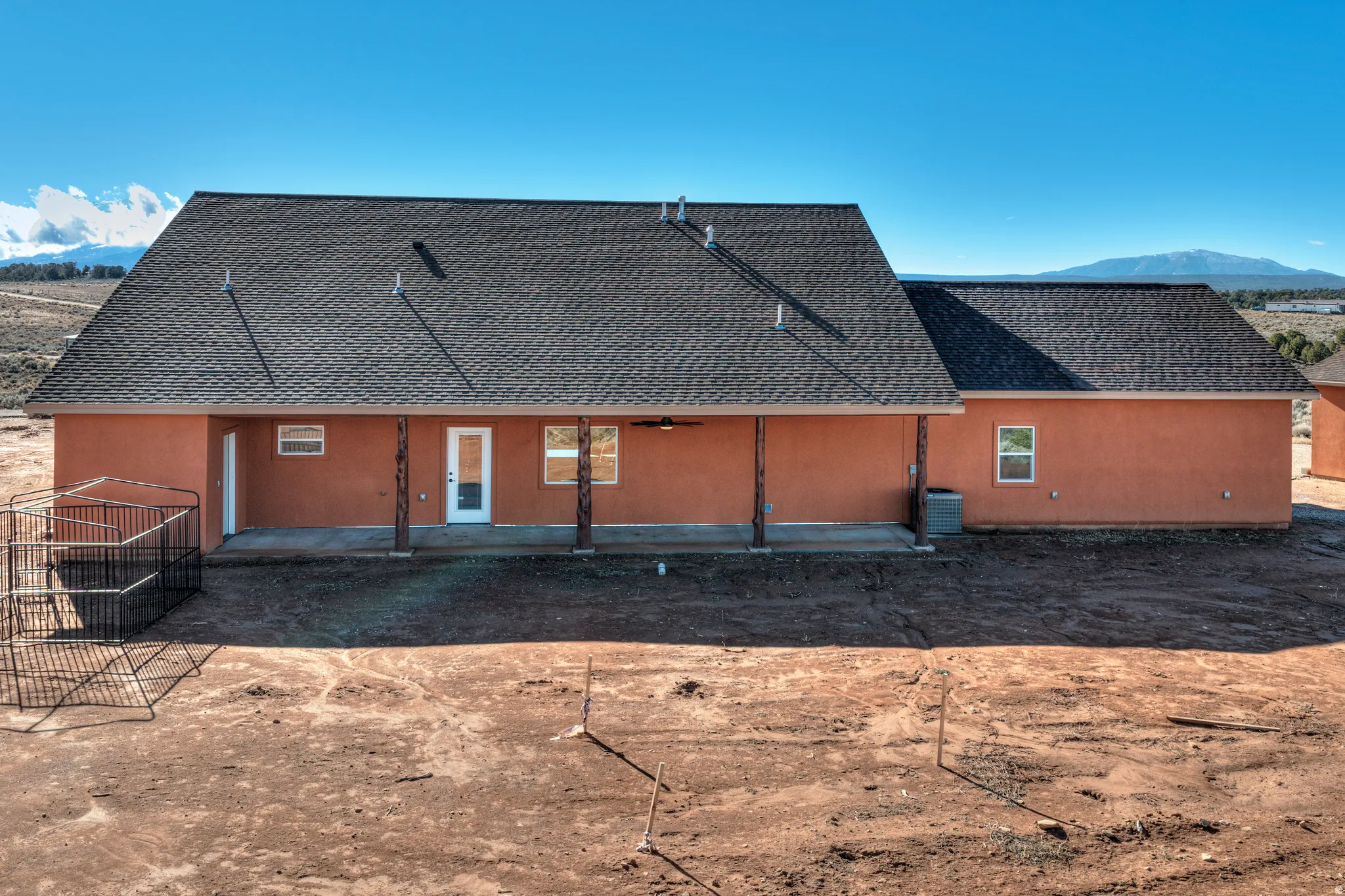Back of house featuring a mountain view, a patio area, and roof with shingles