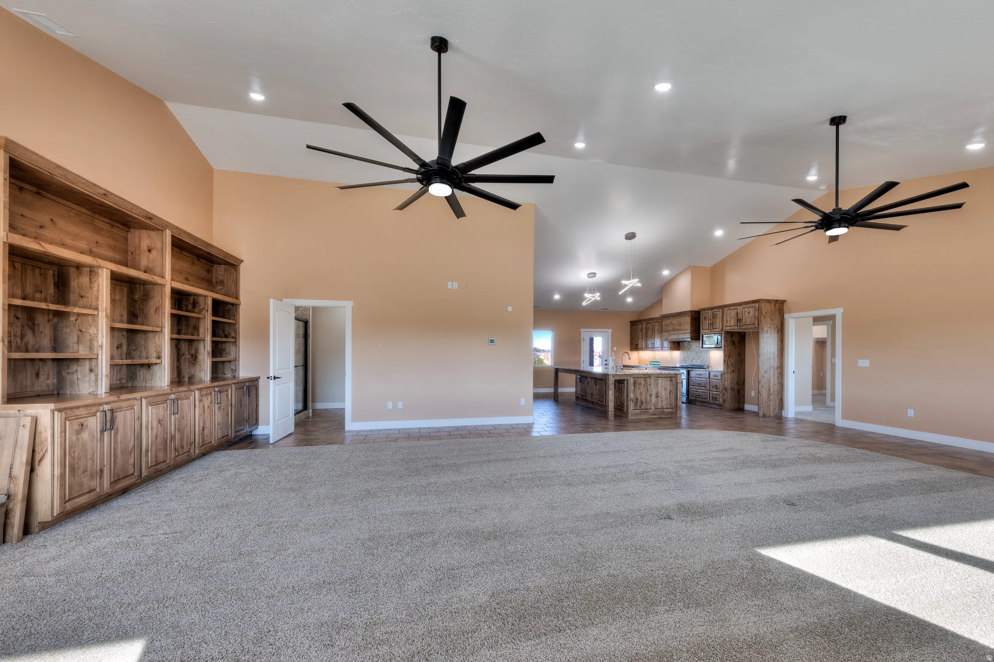 Unfurnished living room with high vaulted ceiling, dark colored carpet, a ceiling fan, and recessed lighting