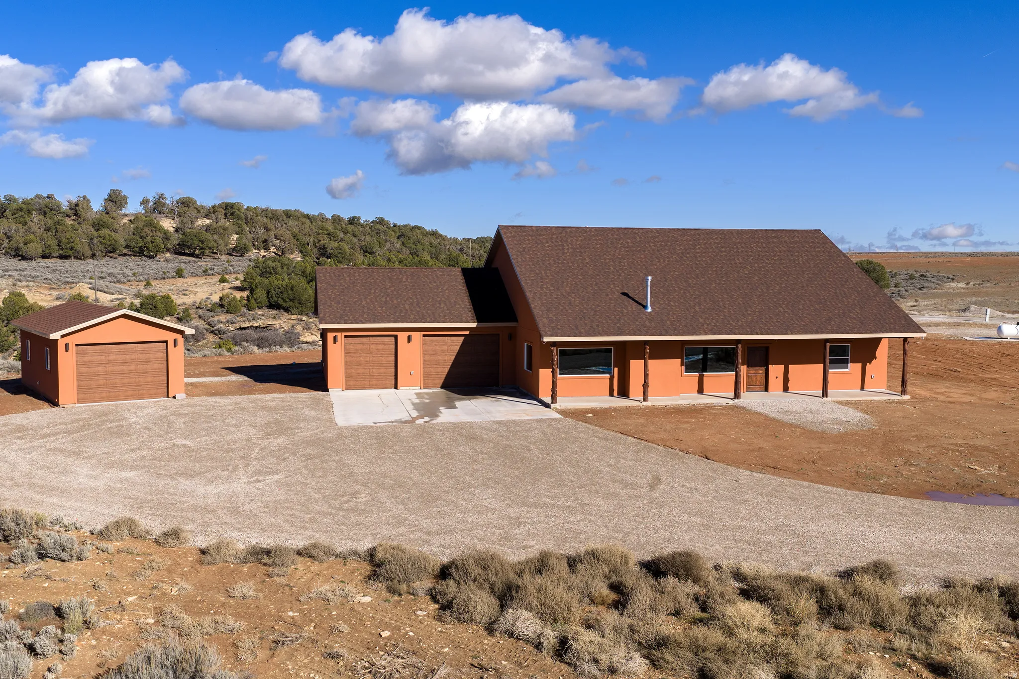 View of front of home featuring roof with shingles and driveway