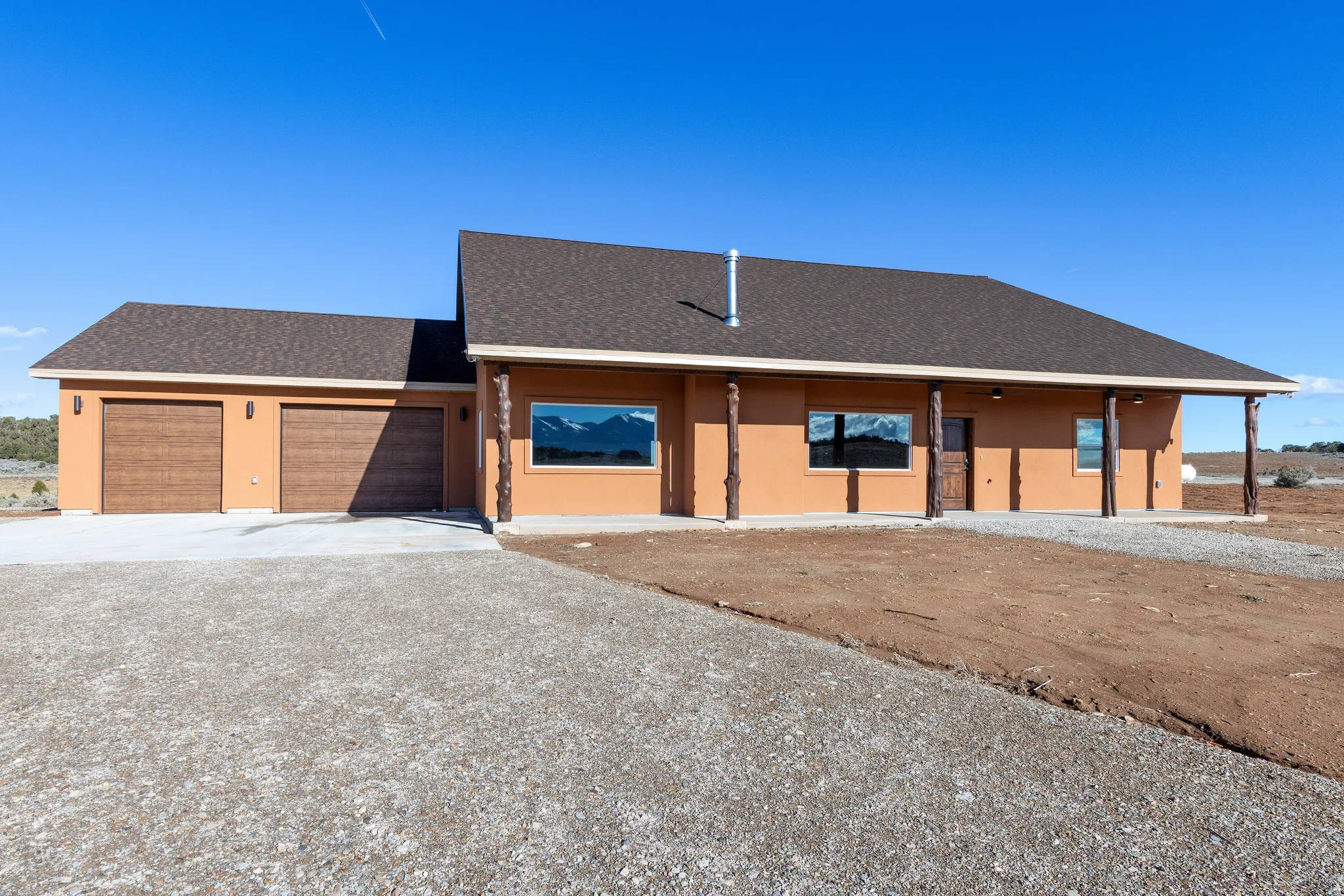 View of front of house featuring a shingled roof, concrete driveway, a garage, and stucco siding