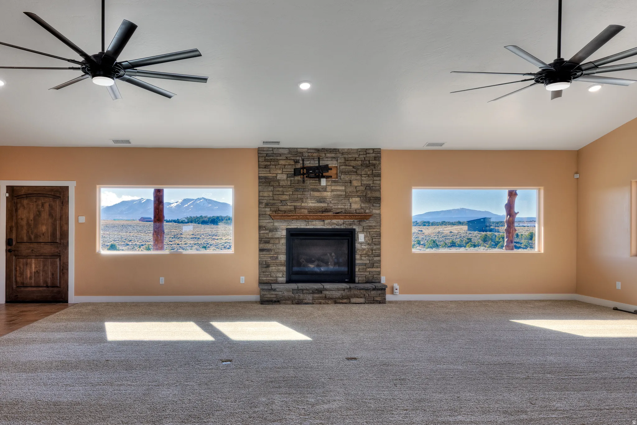 Unfurnished living room featuring ceiling fan, a fireplace, healthy amount of natural light, and recessed lighting
