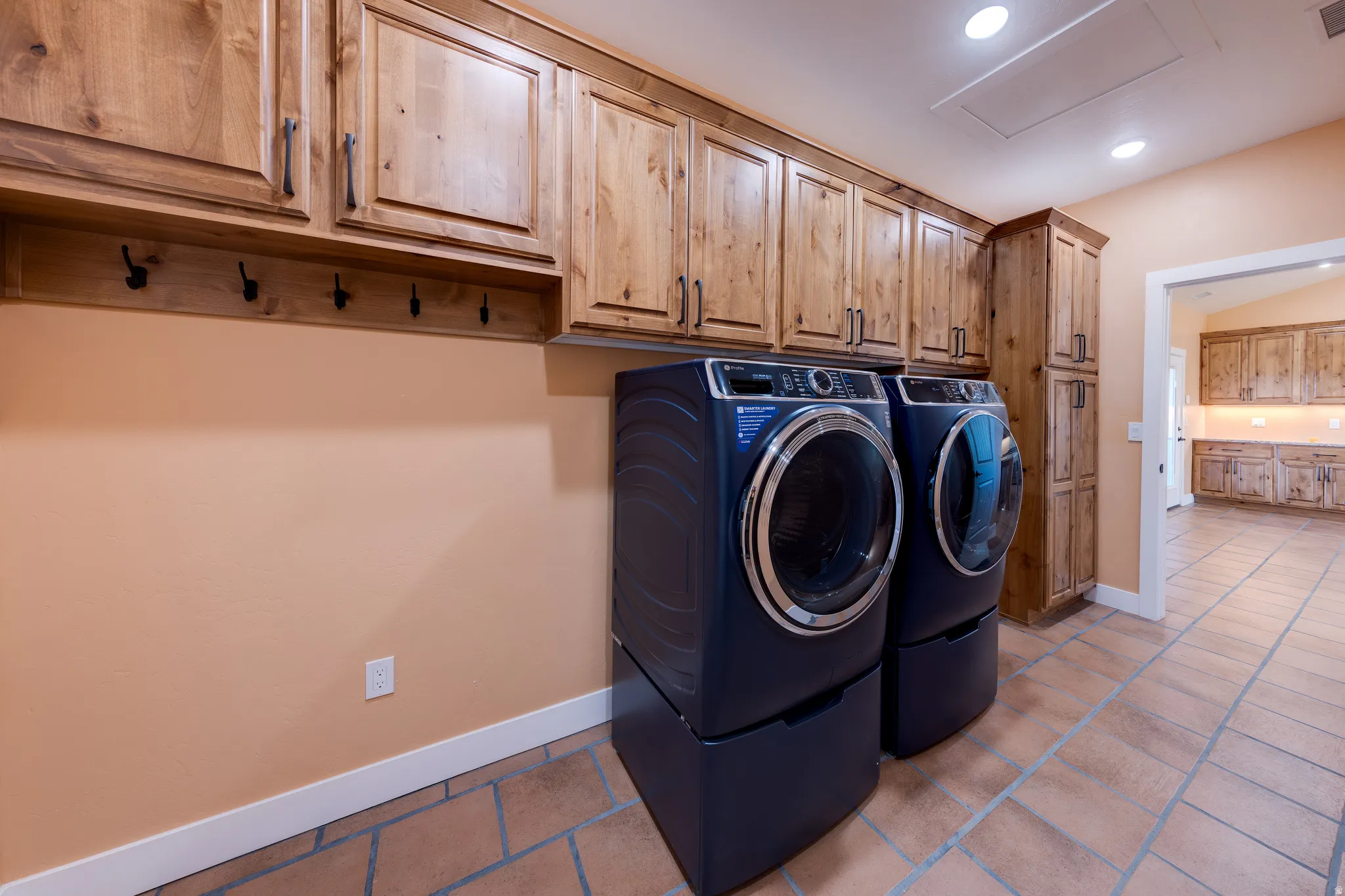 Laundry room with cabinet space, independent washer and dryer, and recessed lighting