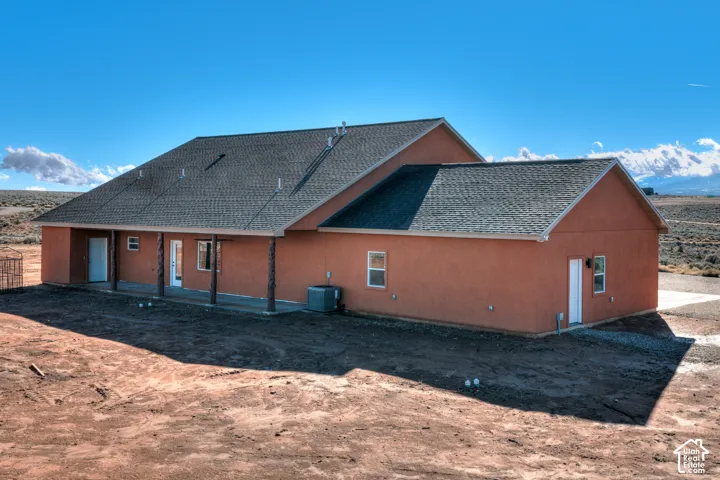 Rear view of property with roof with shingles, a patio area, and stucco siding