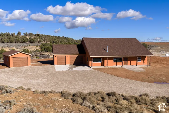 View of front of home featuring roof with shingles and driveway