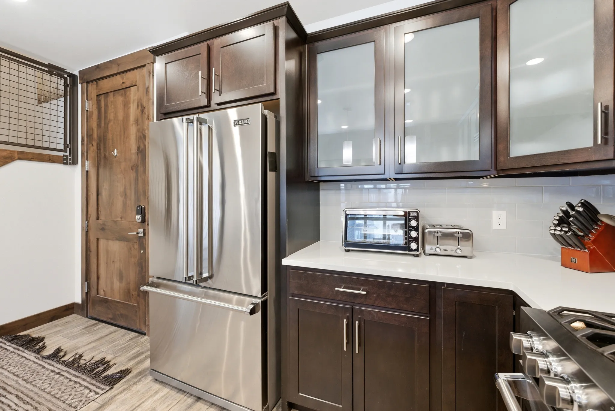 Stainless steel French door refrigerator set against rich wood-finish cabinetry
