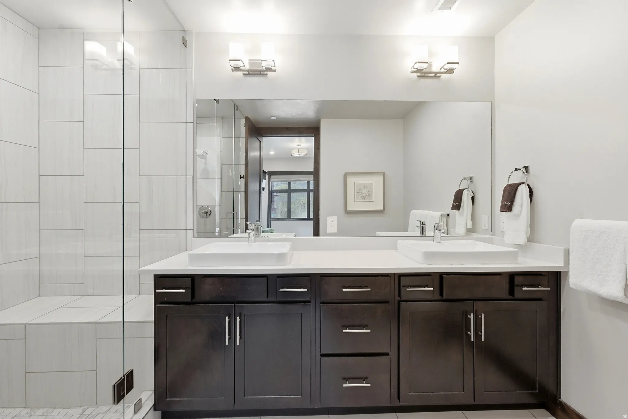 Double vanity with vessel sinks and dark wood-finish cabinetry