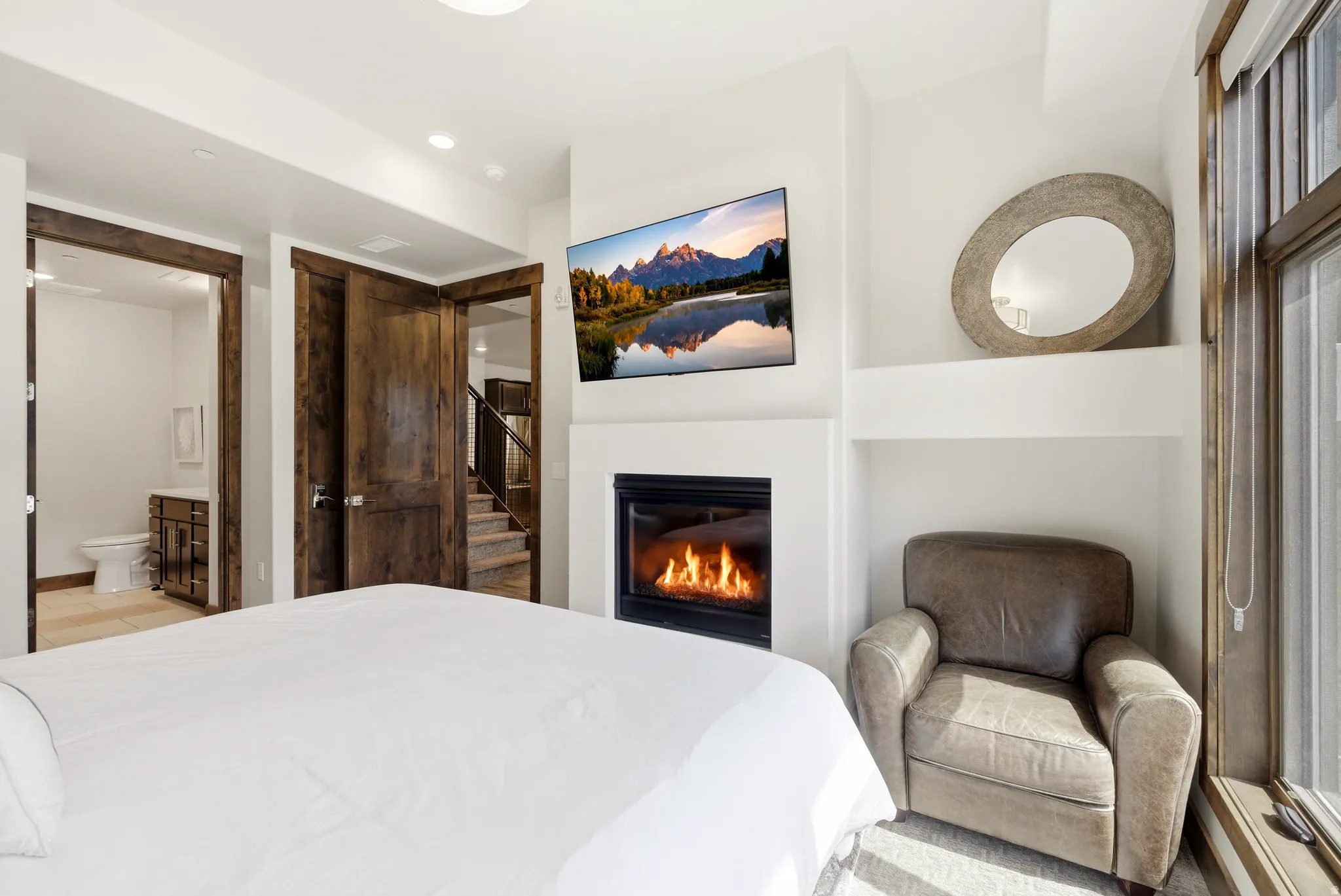 White walls featuring a built-in fireplace, a large window with wood trim, and recessed lighting