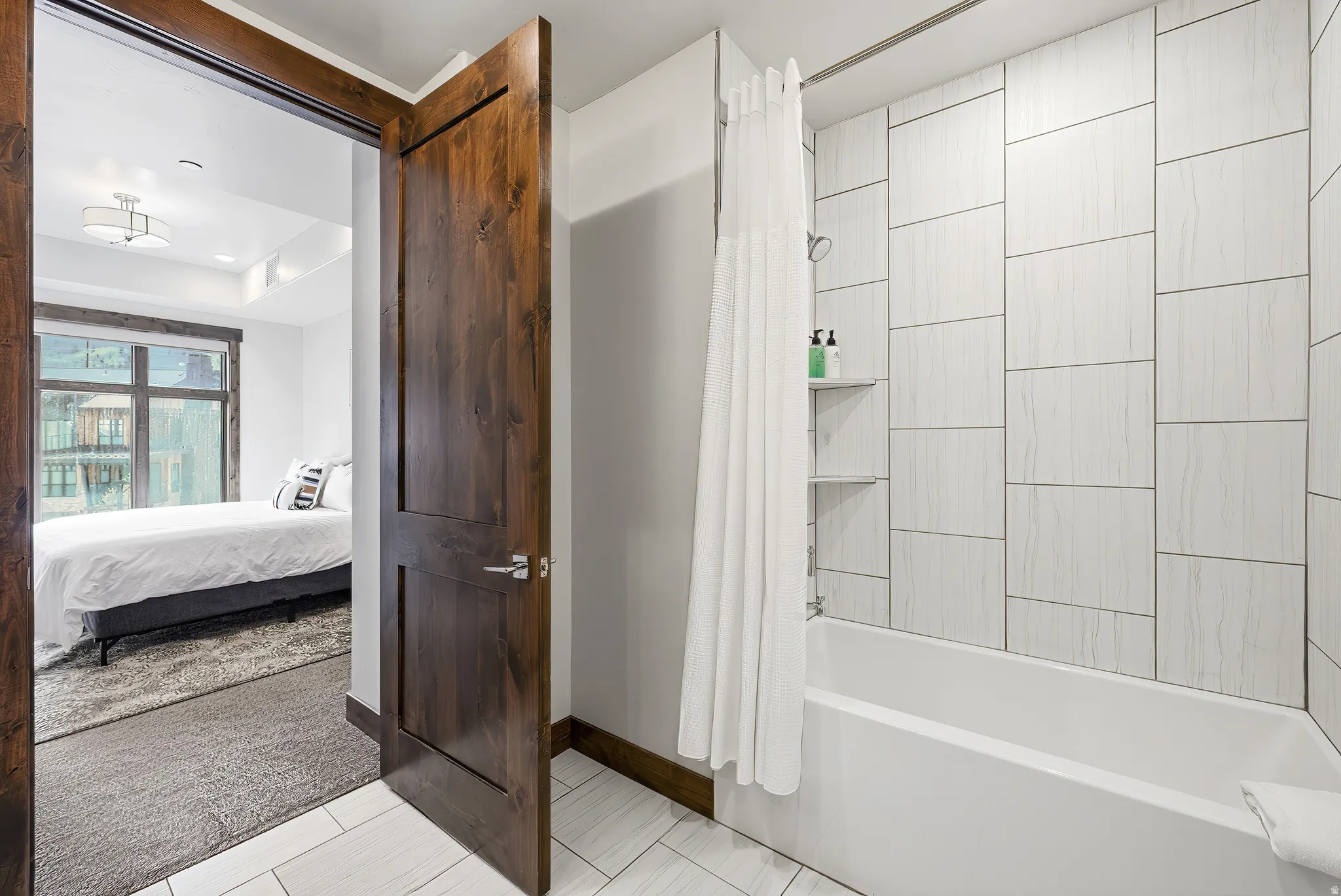 White tiled shower with built-in shelving and tub