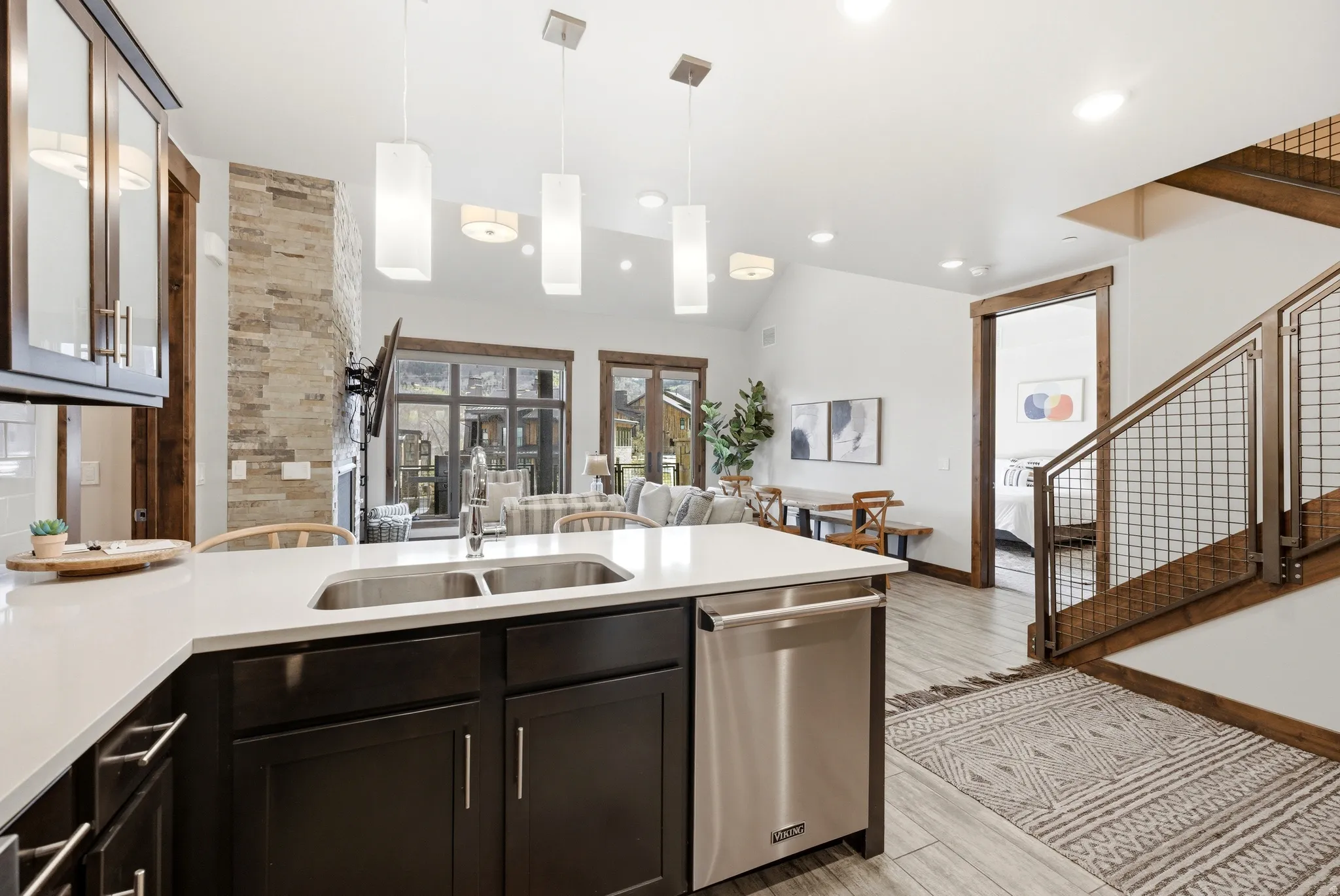 Modern kitchen island featuring a double stainless steel sink, a stainless steel dishwasher, and white countertops