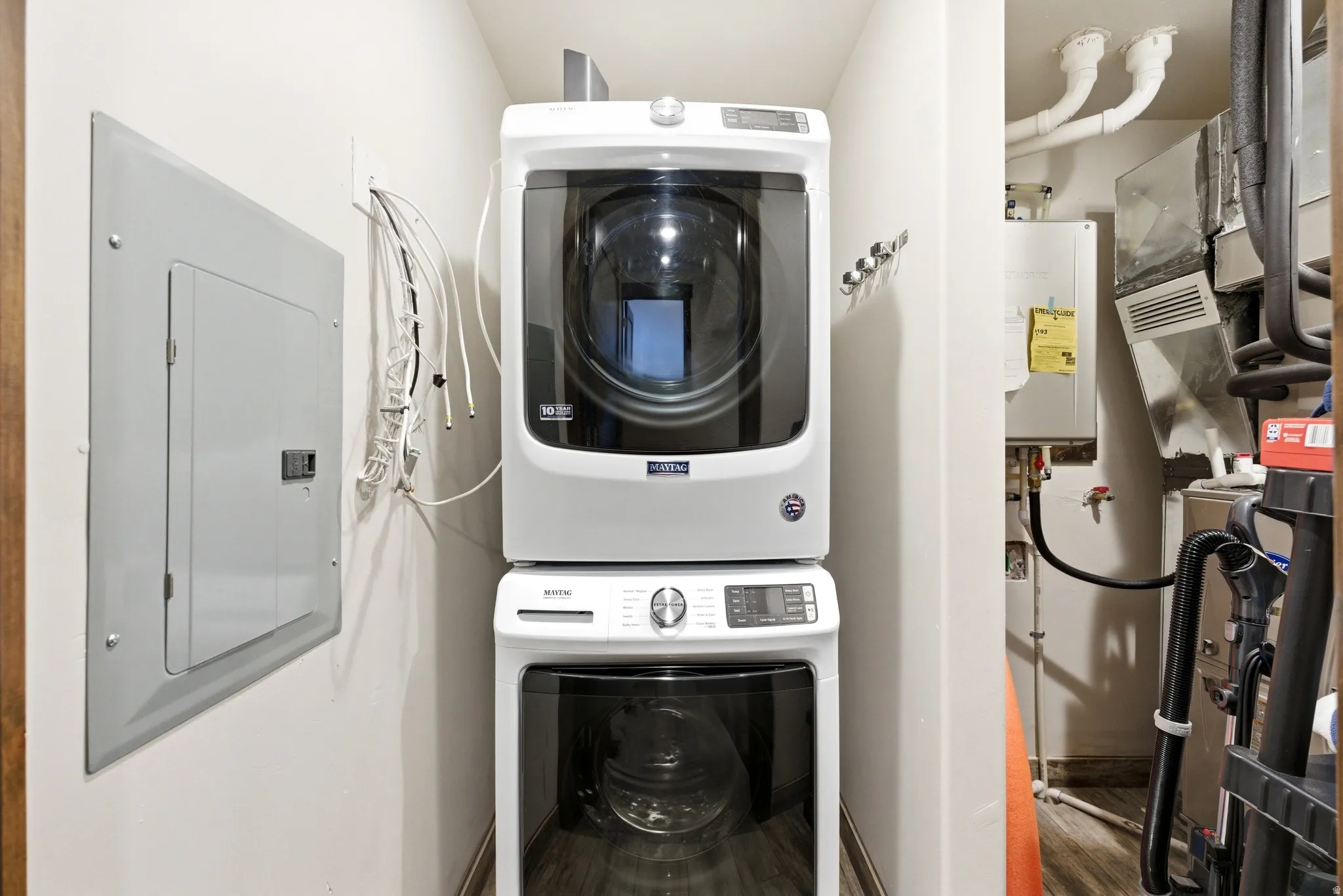 Dedicated laundry area featuring a stacked washer and dryer unit