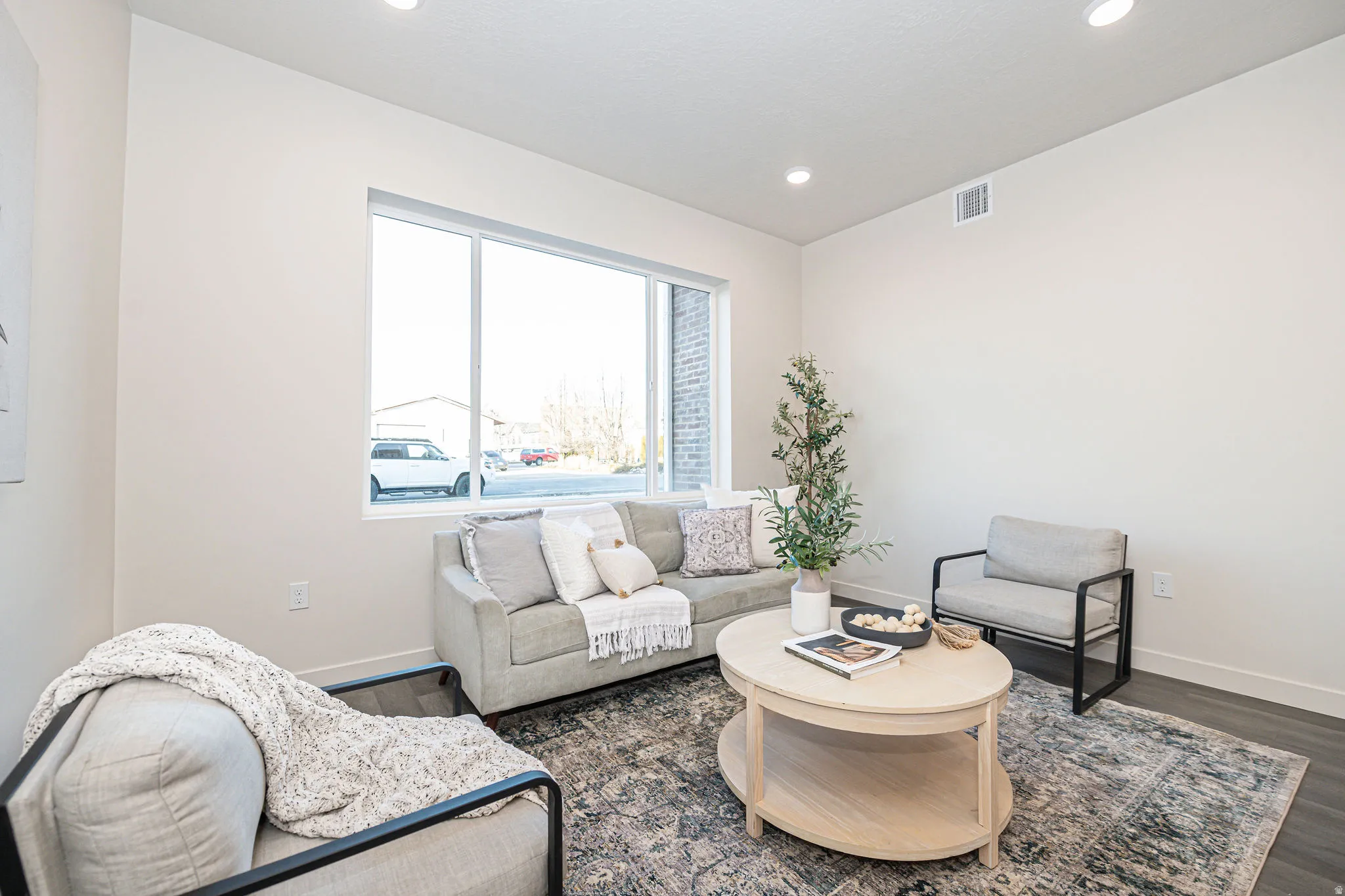 Living area featuring dark wood-type flooring and recessed lighting