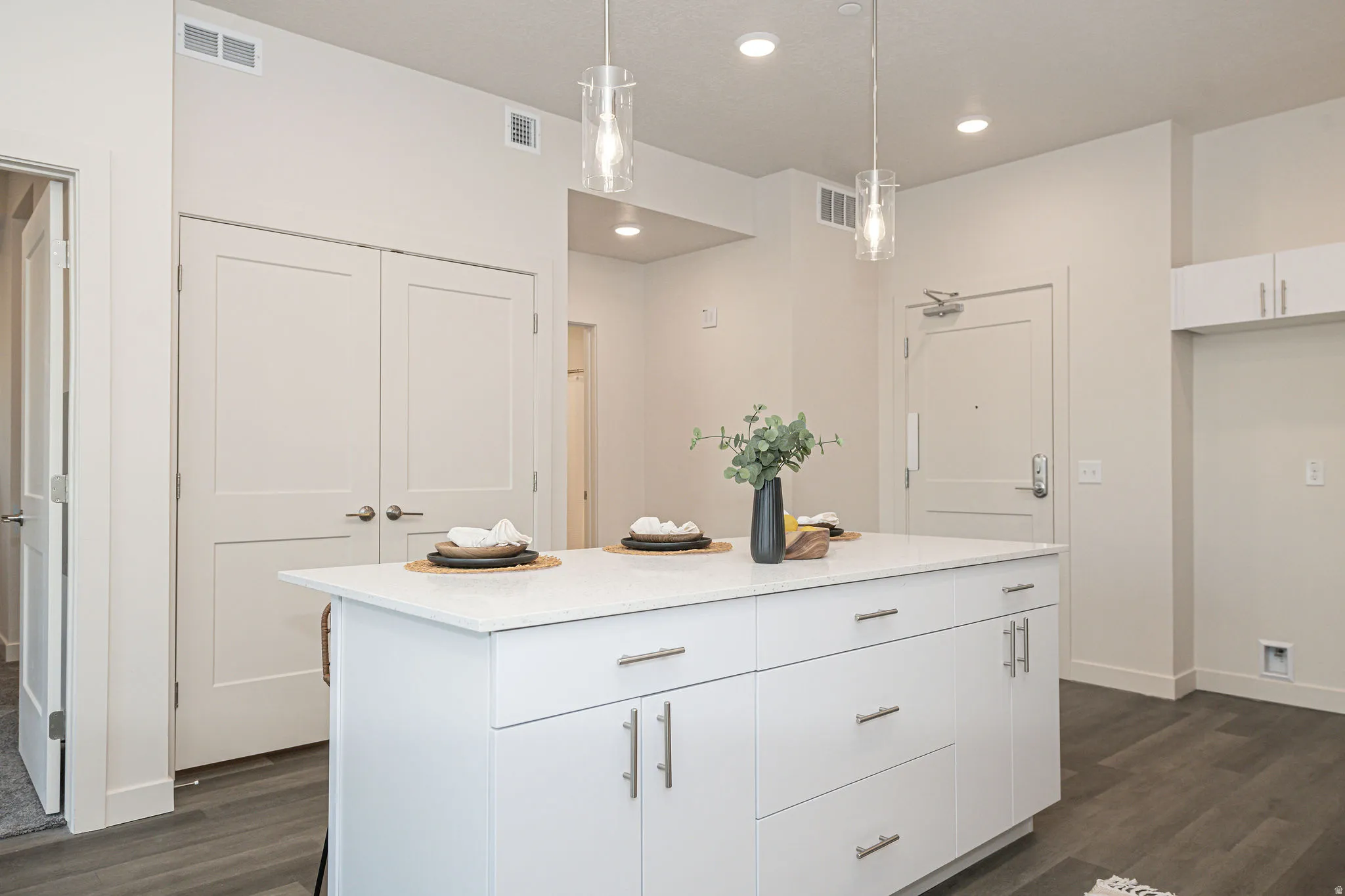 Kitchen featuring white cabinetry, hanging light fixtures, dark wood-style flooring, a center island, and recessed lighting