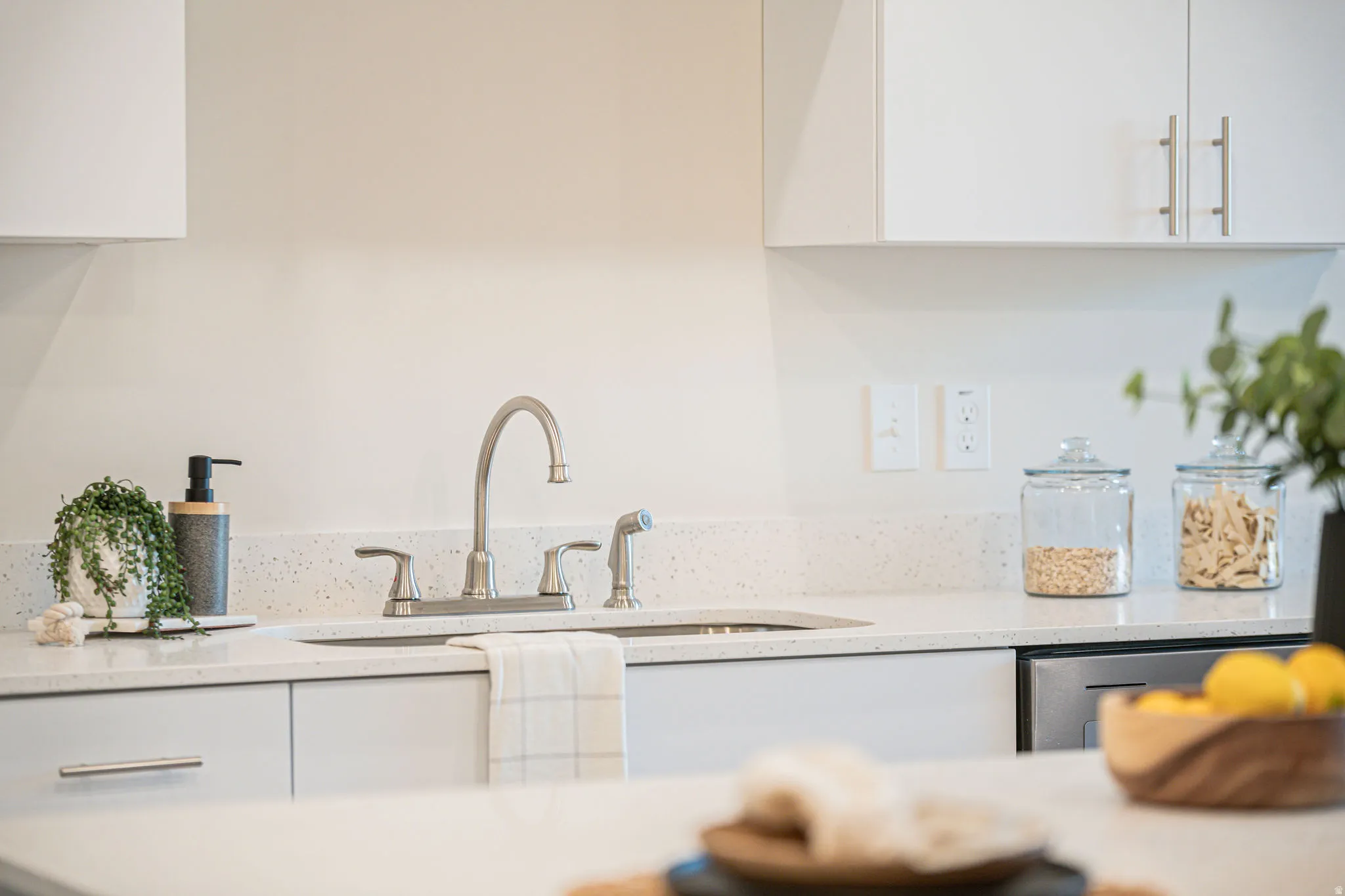Kitchen with white cabinets, light stone countertops, and modern cabinets