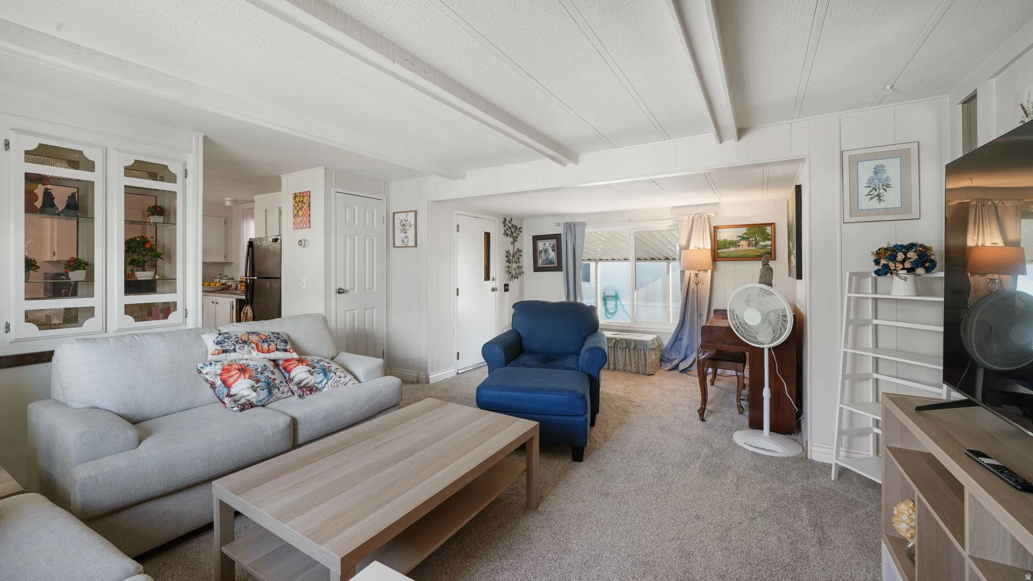 Living area featuring carpet and beamed ceiling