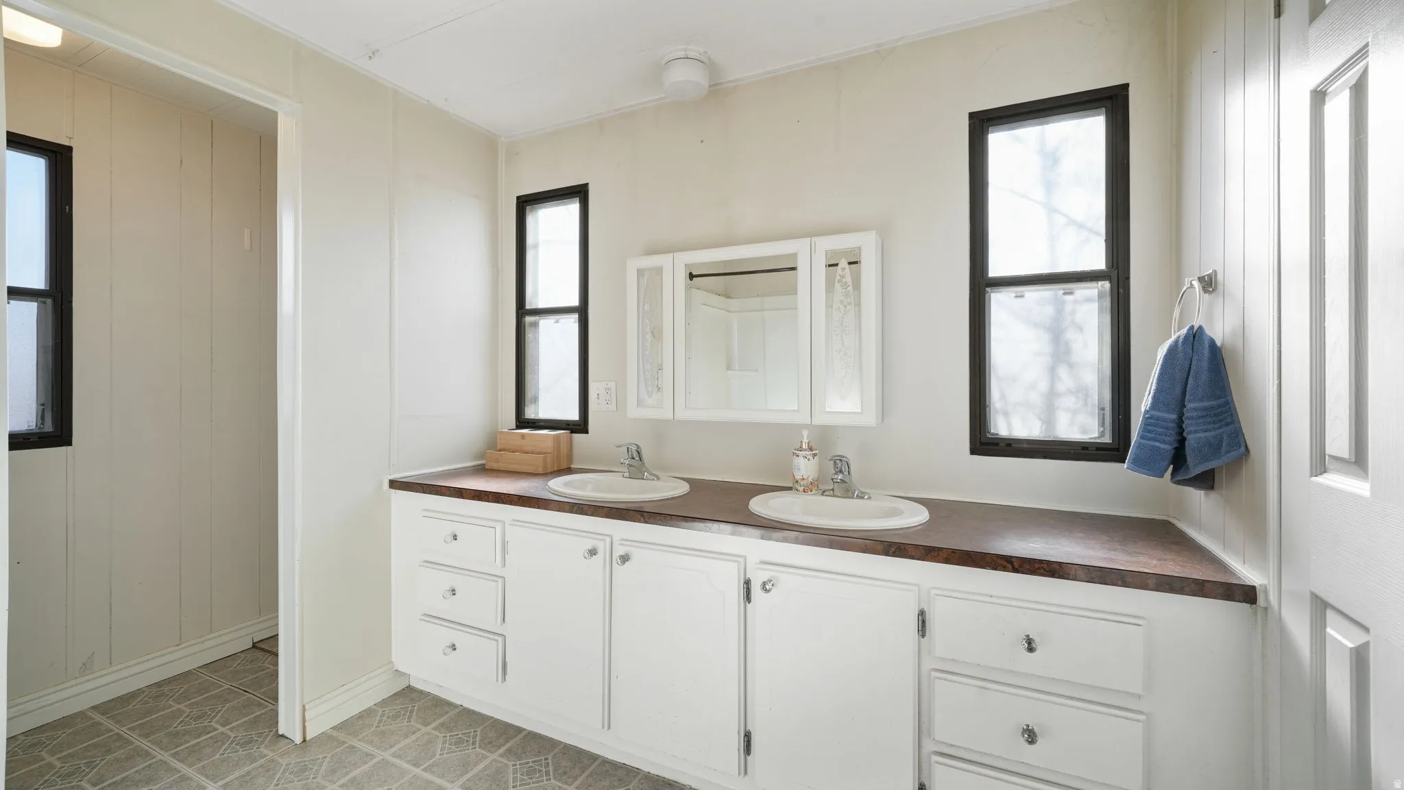 Bathroom featuring double vanity and light tile patterned floors