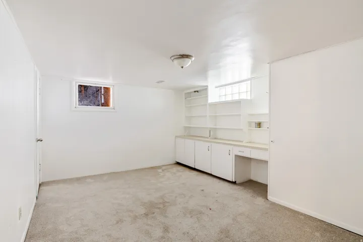 Basement featuring light carpet, built in features, and built in study area
