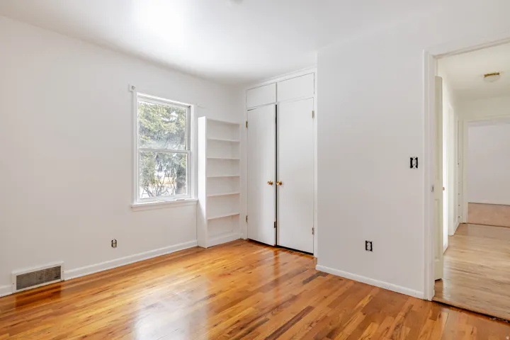 Unfurnished bedroom featuring light wood-style floors and a closet