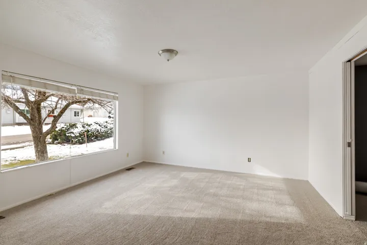 Empty room featuring light colored carpet